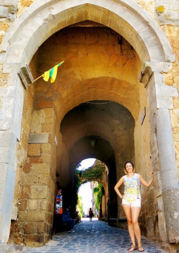 Civita di Bagnoregio Italy, woman standing before the gates to the town