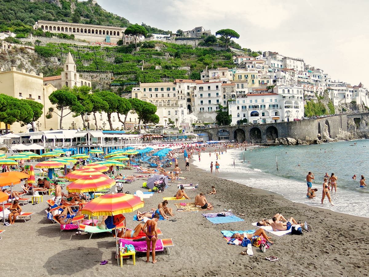 Amalfi Town, Amalfi Coast, Italy, and beach view, sun loungers, beach umbrellas and tourists 