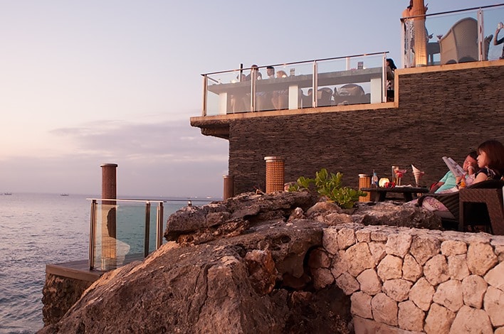 Rock Bar Bali, people relaxing and having a drink in the bar, sunset views over the water