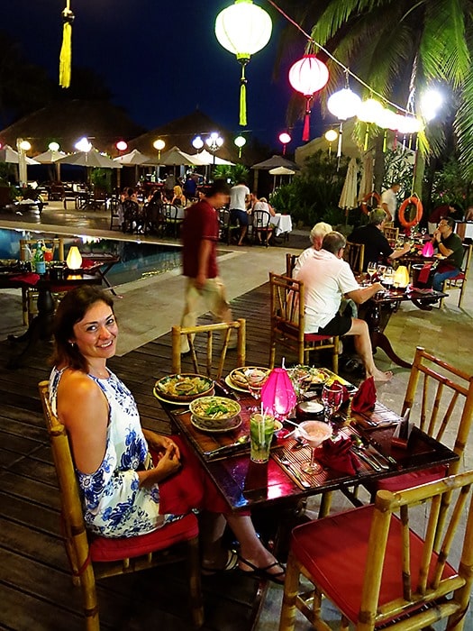 Victoria Hoi An, Vietman, woman sitting at the table wth lots of food, restaurant setting, lanterns hanging over the top