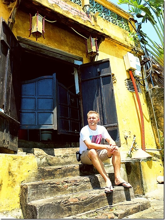 UNESCO World Heritage Site - Hoi An Ancient Town, Vietnam, man sitting on the steps of a yellow building