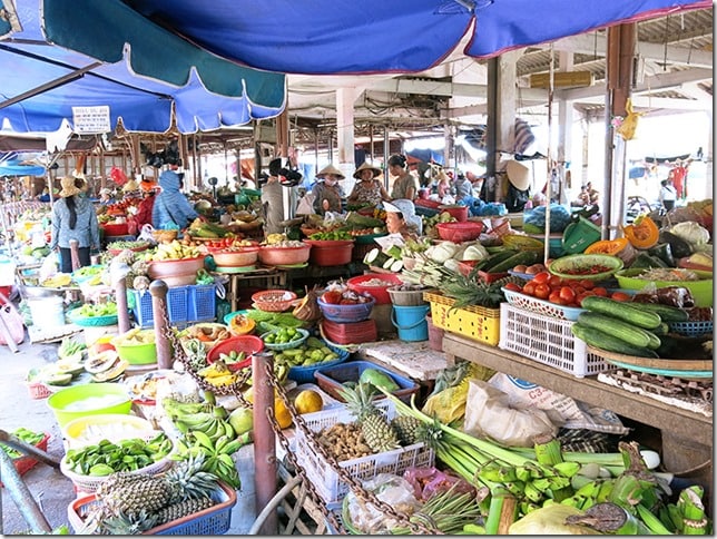 Hoi An Vietnam, fruit and vegetable market, some ladies sitting and standing 