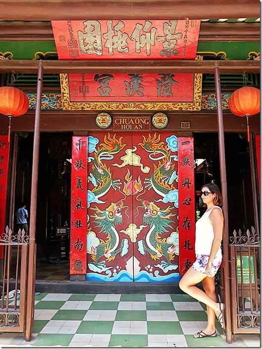 Hoi An Vietnam, Lady standing leaning with one leg on the side of the entrance of the temple Chua Ong Hoi An