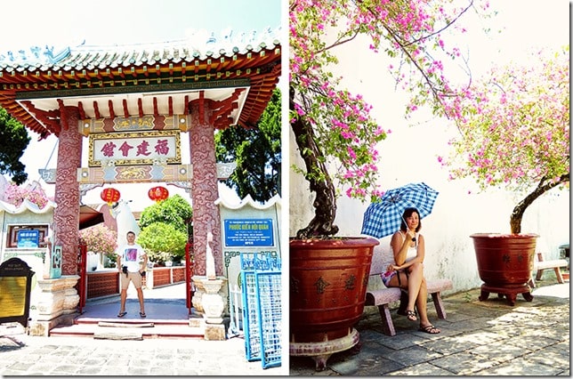 Hoi An Vietnam, Phuc Kien Assembly Hall in Hoi An Old Town, man at the entrance and woman sitting on a seat with an umbrella, pink flower trees