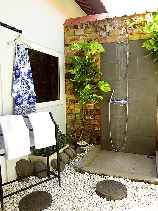 Victoria Hoi An, Vietnam, outdoor shower in the villa, dress on the hanger, towels on the rack