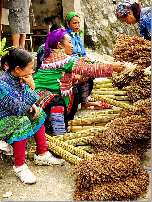 Bac Ha Markets ladies dressed in traditional clothing selling hand made brooms