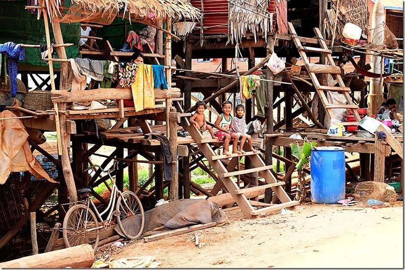 Popular Places to visit in Cambodia - Kampong Khleang, kids sitting on the steps of the wooden house