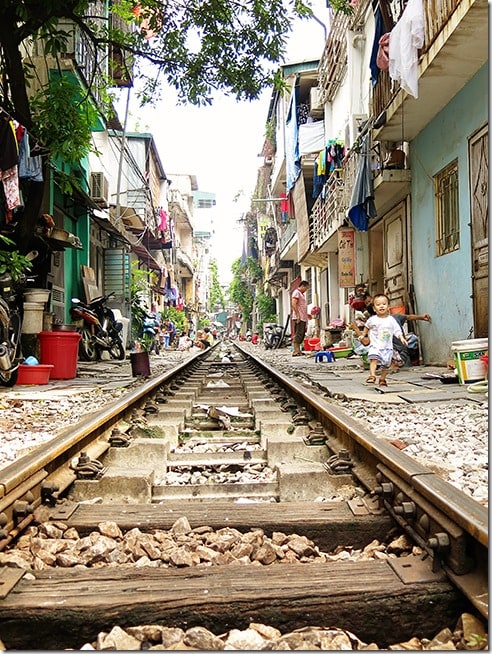 Train tracks in Hanoi Vietnam, kid running, houses close to the tracks