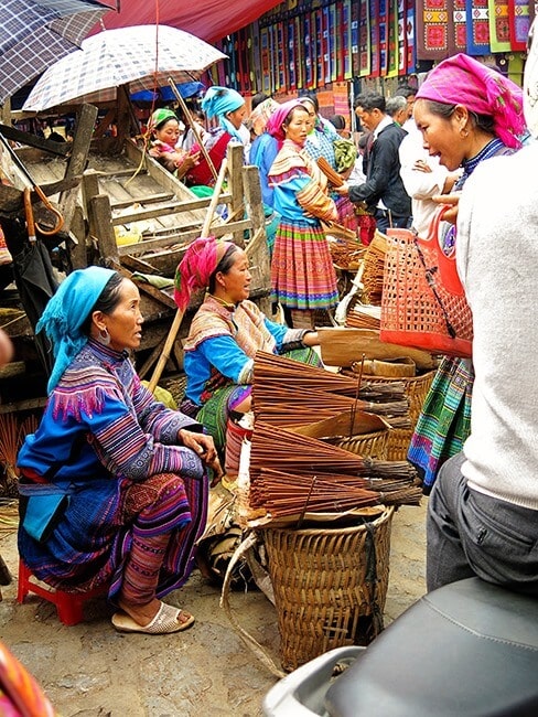 Bac Ha Markets in Sapa in Vietnam, women wearing traditional colourful clothes and selling brooms