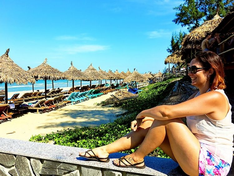 Woman at the beach close to Hoi An, sun loungers and beach umbrellas