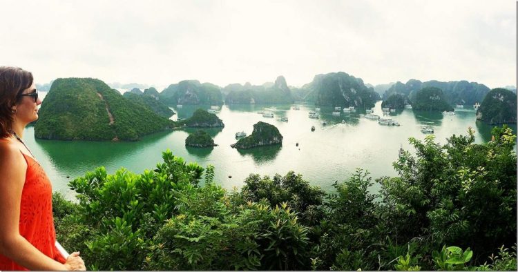 A woman looking out from the view point, Halong Bay, Vietnam, boats and rocky islands down below