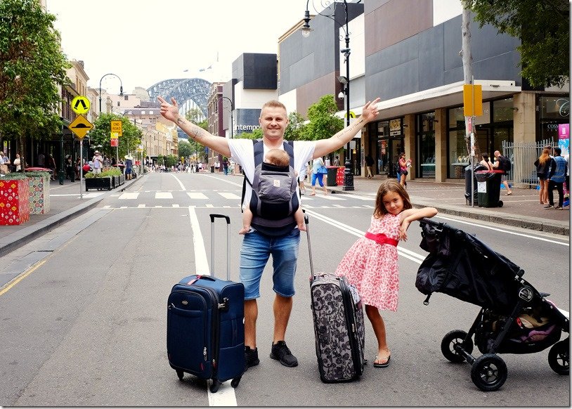 family with luggage in the street of Sydney, view of the Sydney Harbour Bridge