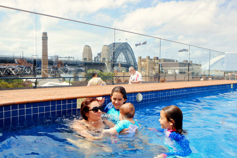 Family in the hotel pool, view of the Sydney Harbour Bridge