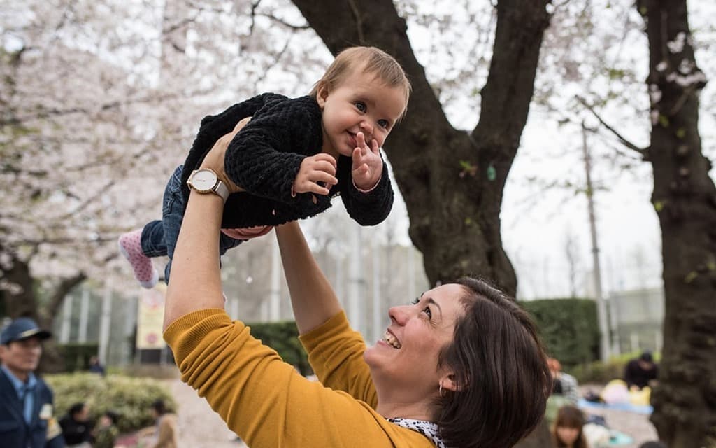 Ueno Park Cherry Blossom, mother holding a baby in the air, smiling