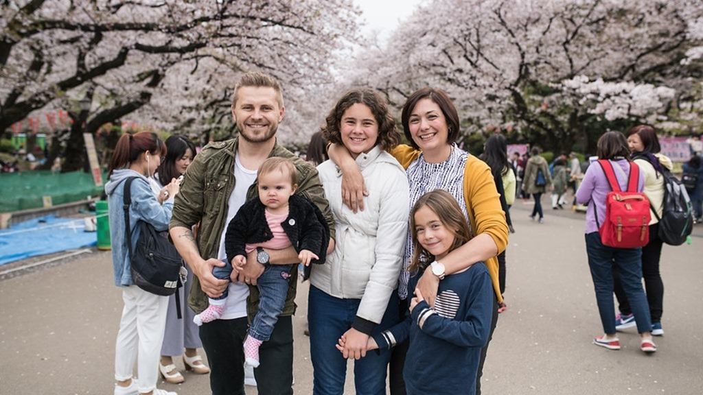 Ueno Park Cherry Blossom, family posing and smiling, pink and white Cherry Blossom trees in background