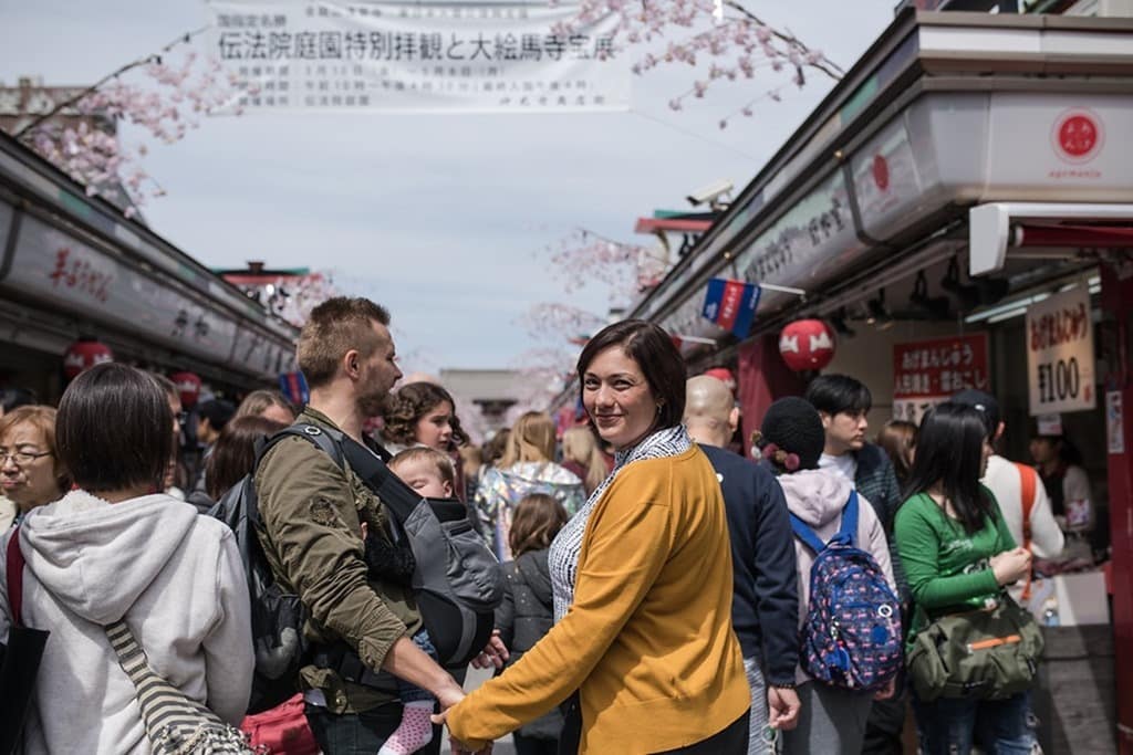 Senso-ji Temple Markets, family in the markets, woman looking back and smiling