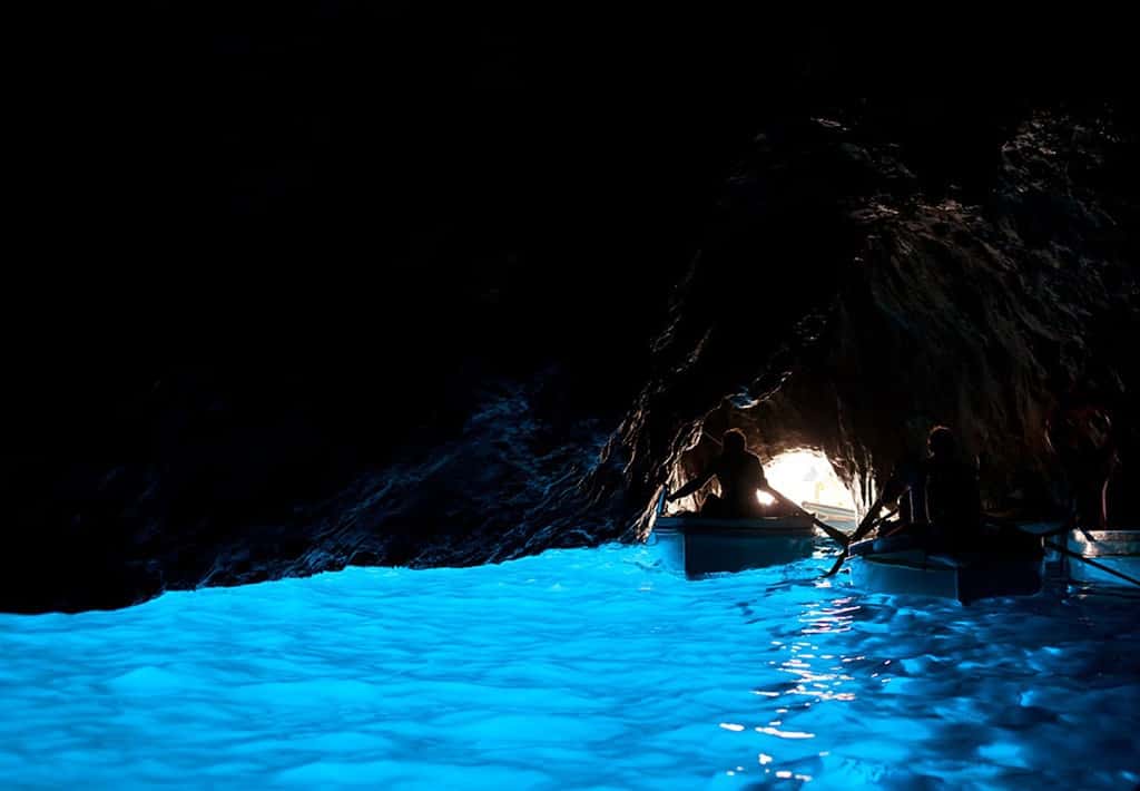 Blue Grotto in Amalfi Coast, light blue water in the cave, 2 boats with people