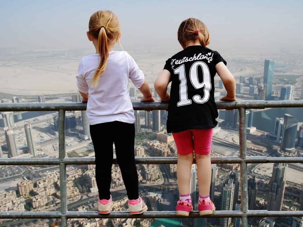 Dubai view point from the top, two kids standing on the railing looking out