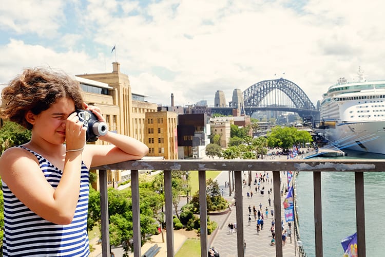 Sydney with Kids, girl taking a photo with a camera, view of the Sydney Harbour Bridge