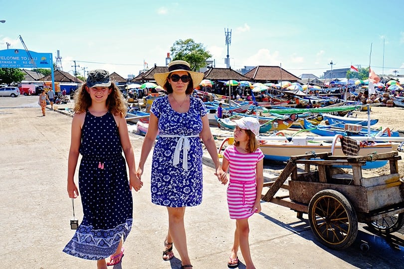 Best Places in South Bali, Indonesia, mother and two daughters walking on the pier, boats and fishing village