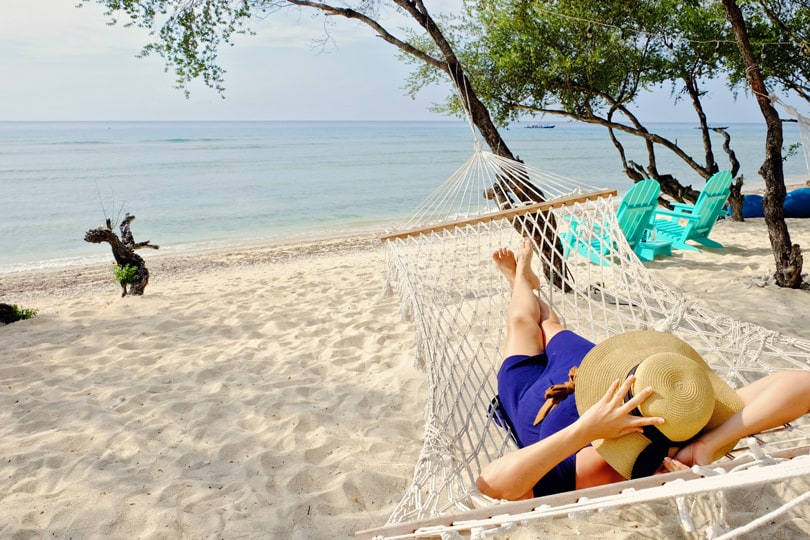 Gili Island, Indonesia, woman in blue dress laying in the hammock, beach view and ocean