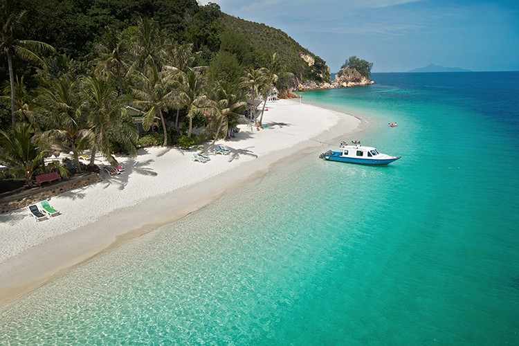 Rawa island. Malaysia, view from above, boat anchored to the shore, turquoise water, white sandy beach and palm trees