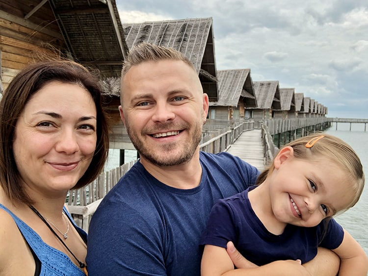 Telunas Private Island, Indonesia, mother, father and a toddler standing on the over water path, over water villas