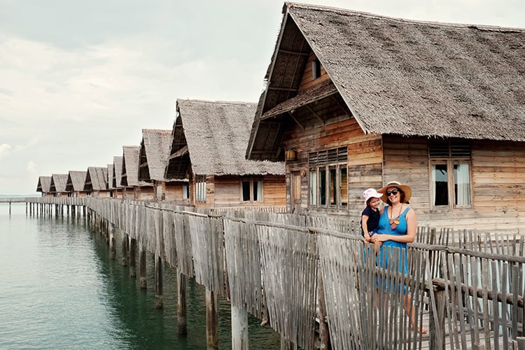 Telunas Private Island, Indonesia, mother and a toddler standing on the over water path, over water villas