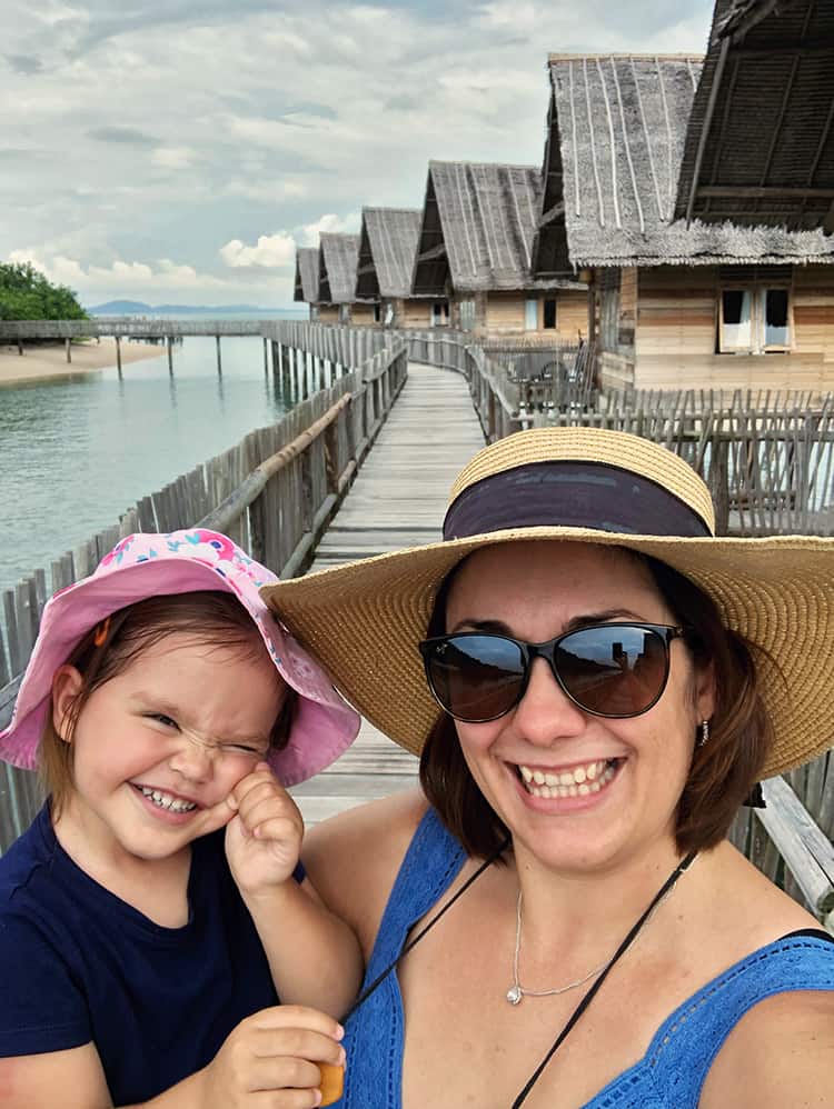 Telunas Private Island, Indonesia, mother and a toddler standing on the over water path, over water villas