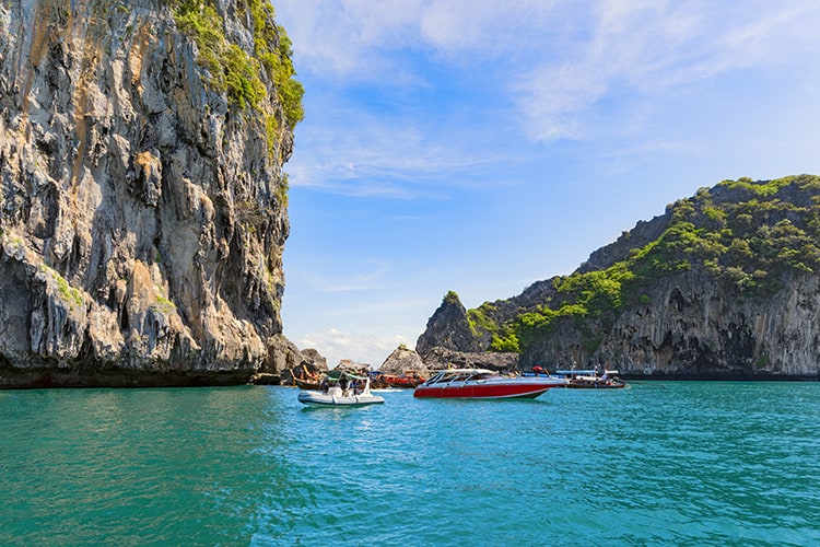 Boats in the sea near the island of Muk, is the famous Emerald Cave or Morakot Cave