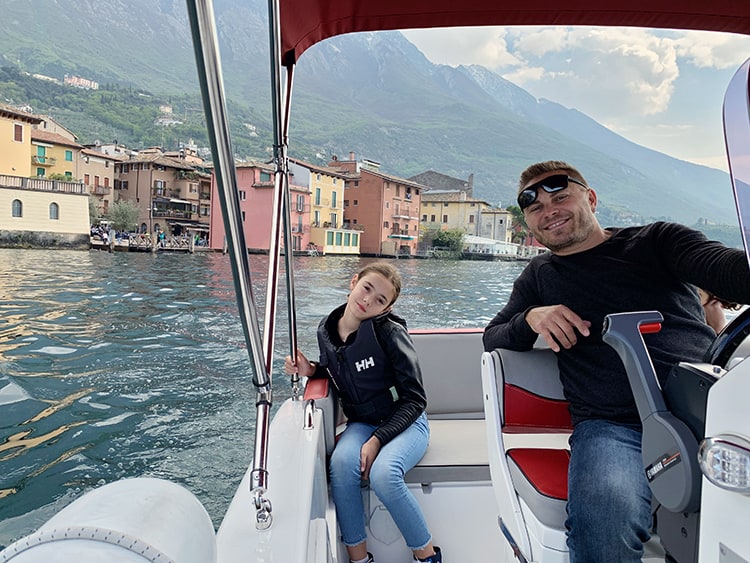 father and daughter on a rental boat in Lake Garda Italy