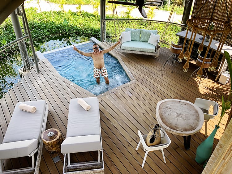 Treehouse Villas Private Pool, sun loungers, bar and seat swing, man standing arms up in the pool