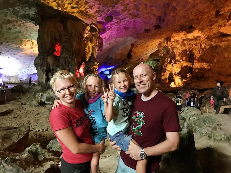 Family in the cave lite up with colourful lights, Halong Bay, Vietnam