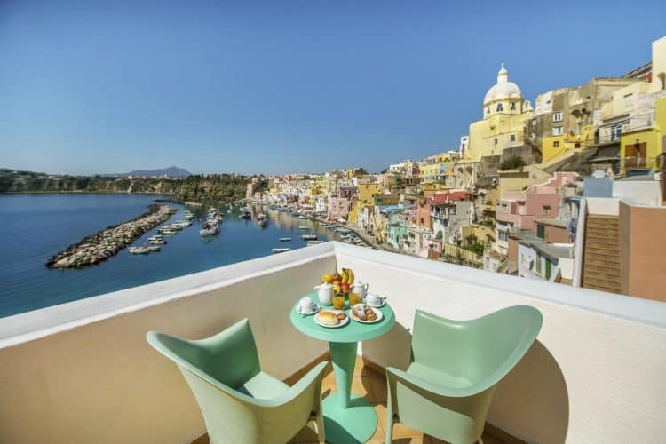 Hotel La Corricella, Procida, Italy, green outdoor dining set for two, food on the table, view of Marina Corricelli
