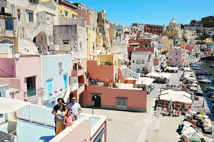 Marina Corricella Procida Italy, family posing on the roof top balcony, colourful building in the background