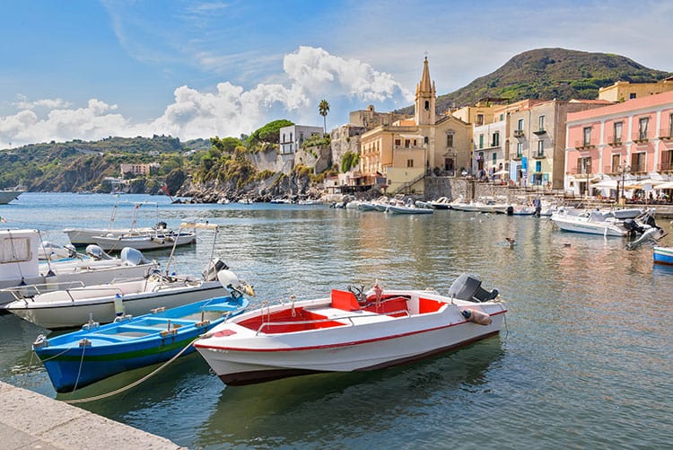 Lipari Island, Italy, few motor boats in the harbour, church and other buildings on the shore