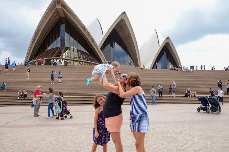 Mother holding her baby up in the air, two other daughters smiling, Sydney Opera House, Sydney, Ausrtalia