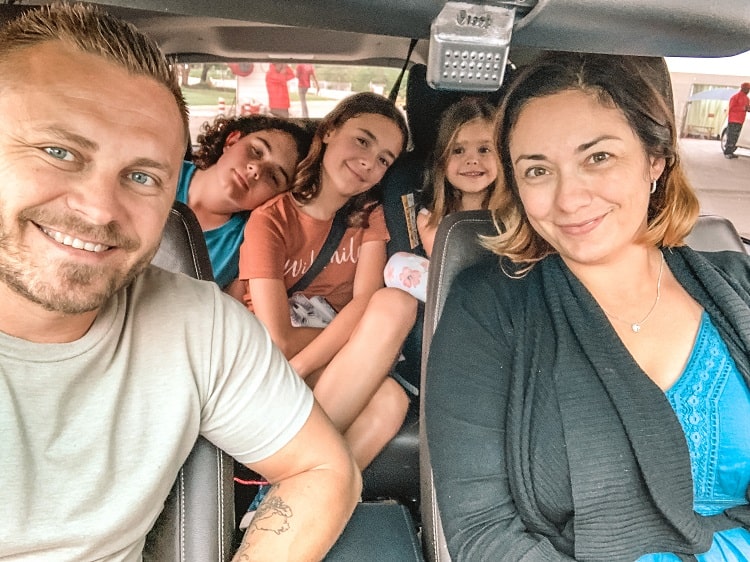 Kruger National Park, South Africa, family smiling and sitting in the car, mother and father in the front seats, kids in the back