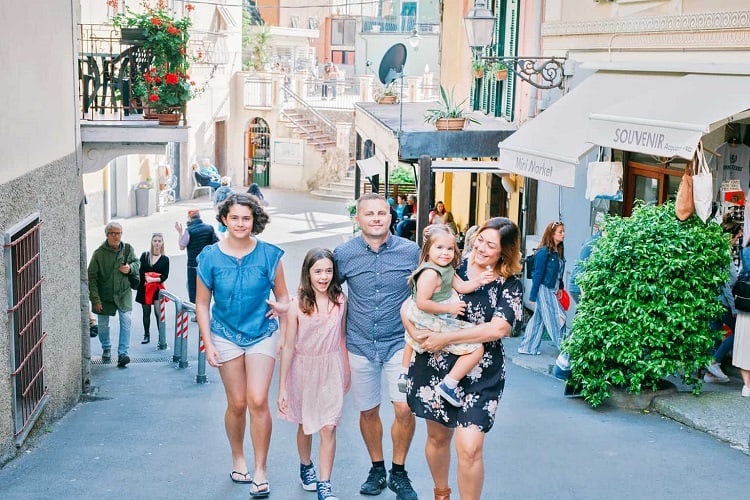 Family walking up the street in Manarola Chinque Terre, Italy, smiling