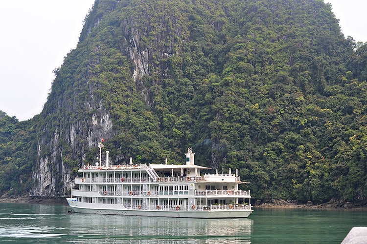 Au-Co-Cruises, cruise boat in the water white ship, rocky island in background, Vietnam, Halong Bay