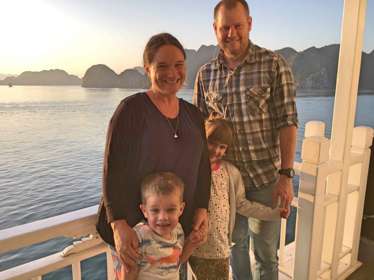 Bhaya-Cruises-Halong-Bay, family posing for a sunset photo with rocky island in teh back