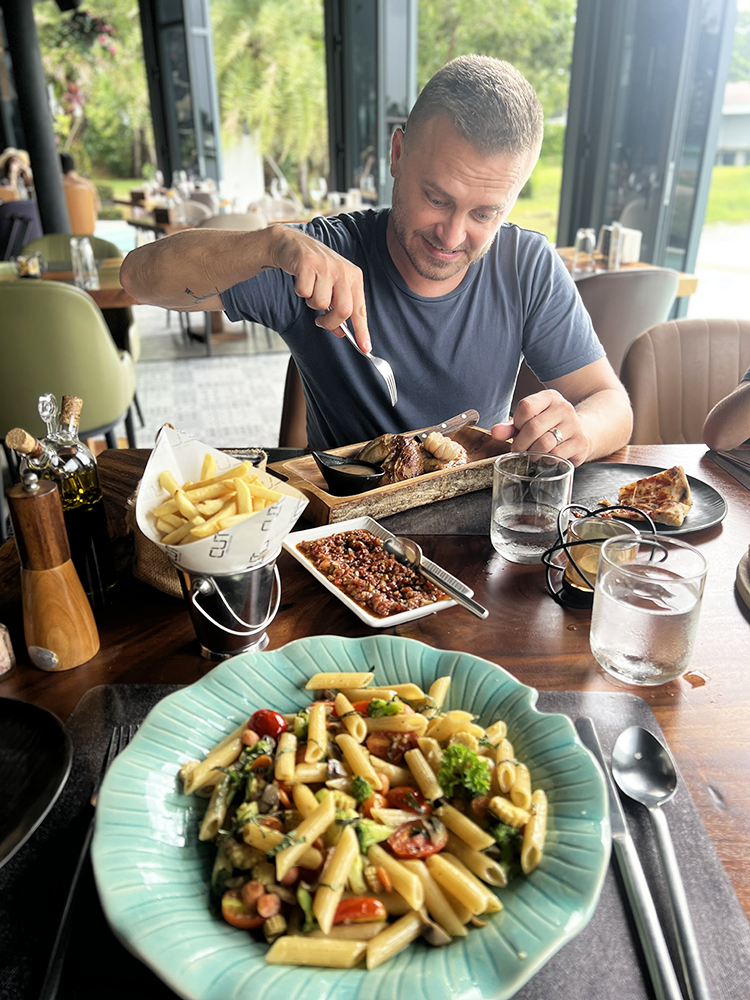 Men eating food chicken and pasta at CUT Grill and Lounge in Phuket