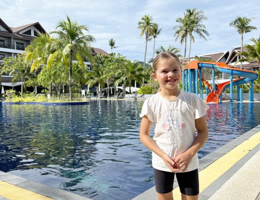 Sunwing Kamala Beach Resort - Girls standing in front of a large pool, pool slides in the back