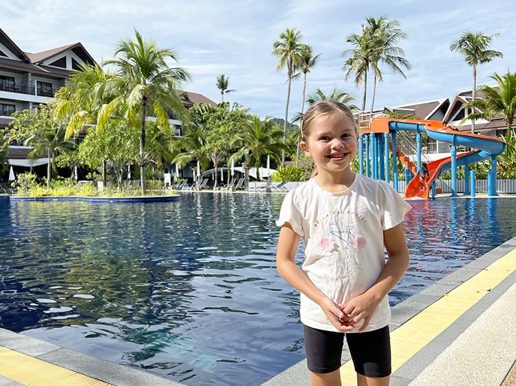 Sunwing Kamala Beach Resort - Girls standing in front of a large pool, pool slides in the back