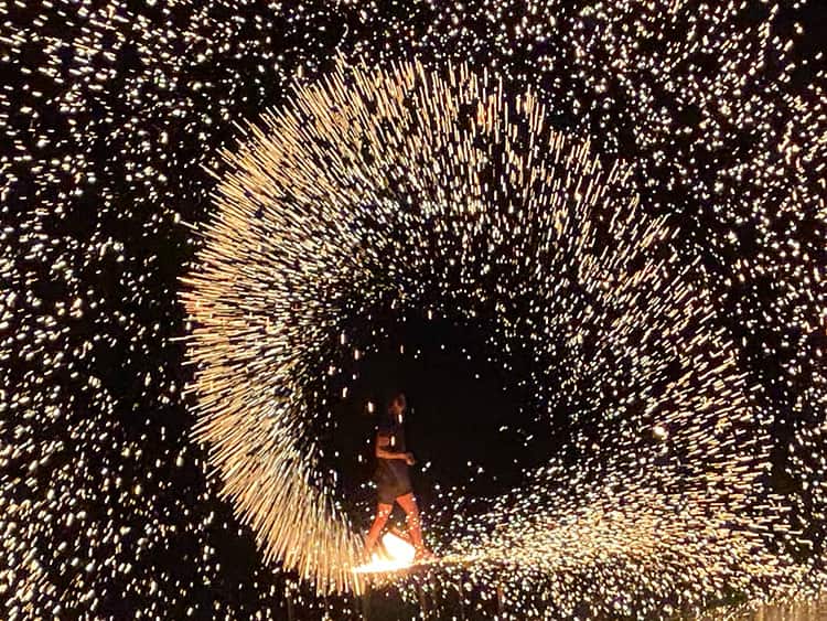 Coco Tams Fire Show, Koh Samui, Thailand, man twirling fire, thousands of fire sparks flying in a circular motion