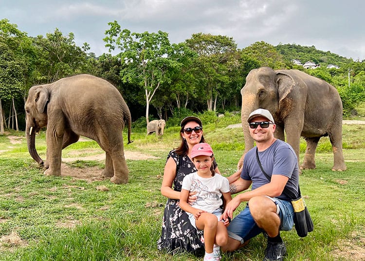 Koh Samui Elephant Haven Sanctuary, Thailand..  family photo with elephants in the background