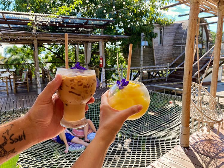 Drinks and coffee at the Mud Cafe, Koh Samui, Thailand, hands holding drinks, restaurant in the background