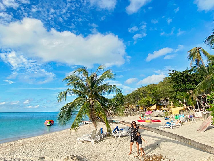 Thongson Bay Beach, Koh Samui, Thailand, mother and daughter standing in front of the palm tree, beach chairs, water sports