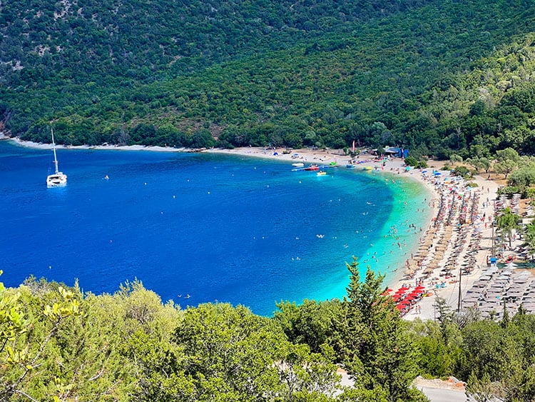 Antisamos Beach, view from the top, Things to do in Kefalonia, Greece, lots of beach umbrellas, sailing boat in the water