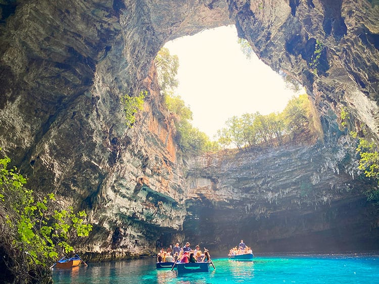 Melissani Cave, Kefalonia, Greece, Things to do in Kefalonia, people in boats inside the cave with circular opening in the roof of the cave,